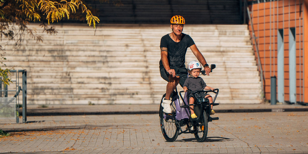 Une famille sur un vélo électrique cargo violet